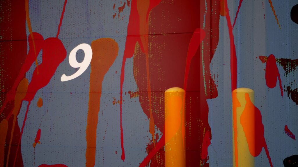 Colorful abstract mural featuring the number nine and bold paint splashes.