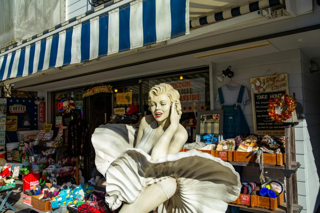 A retro shop façade featuring a Marilyn Monroe statue in Karuizawa, Japan, with various merchandise displayed outside.
