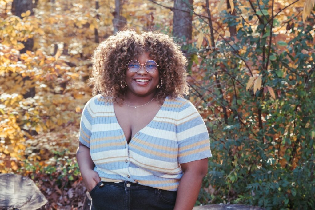 a woman standing in front of some trees