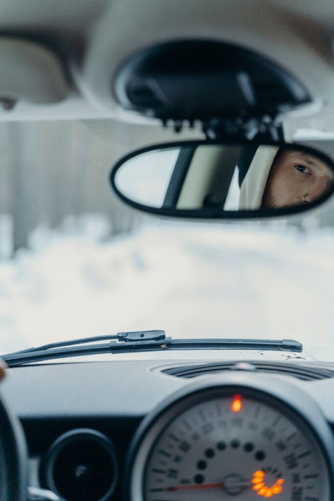 View of a car interior focusing on rearview mirror reflection and dashboard detail.