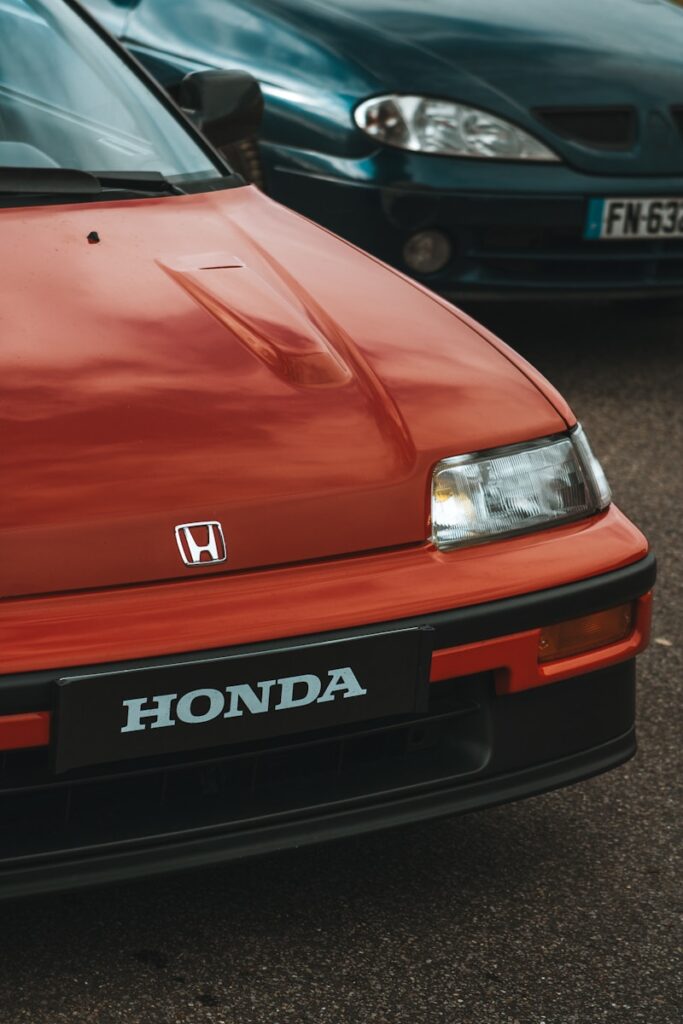 Two honda cars parked next to each other in a parking lot