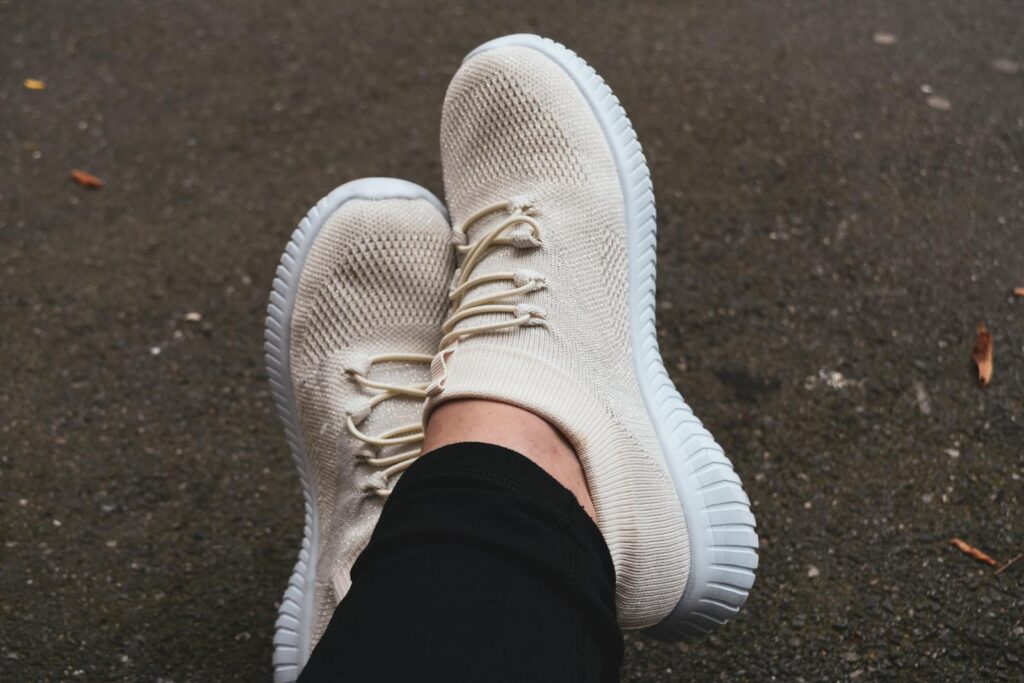 Fashionable cream sneakers on pavement, showcasing casual urban style.