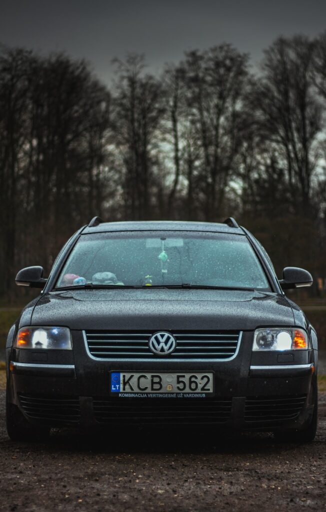 a black car parked in front of some trees