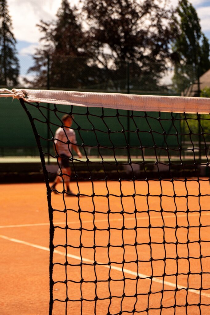 A tennis court with a net and two people on it