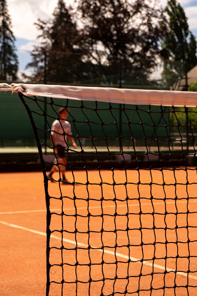 A tennis court with a net and two people on it