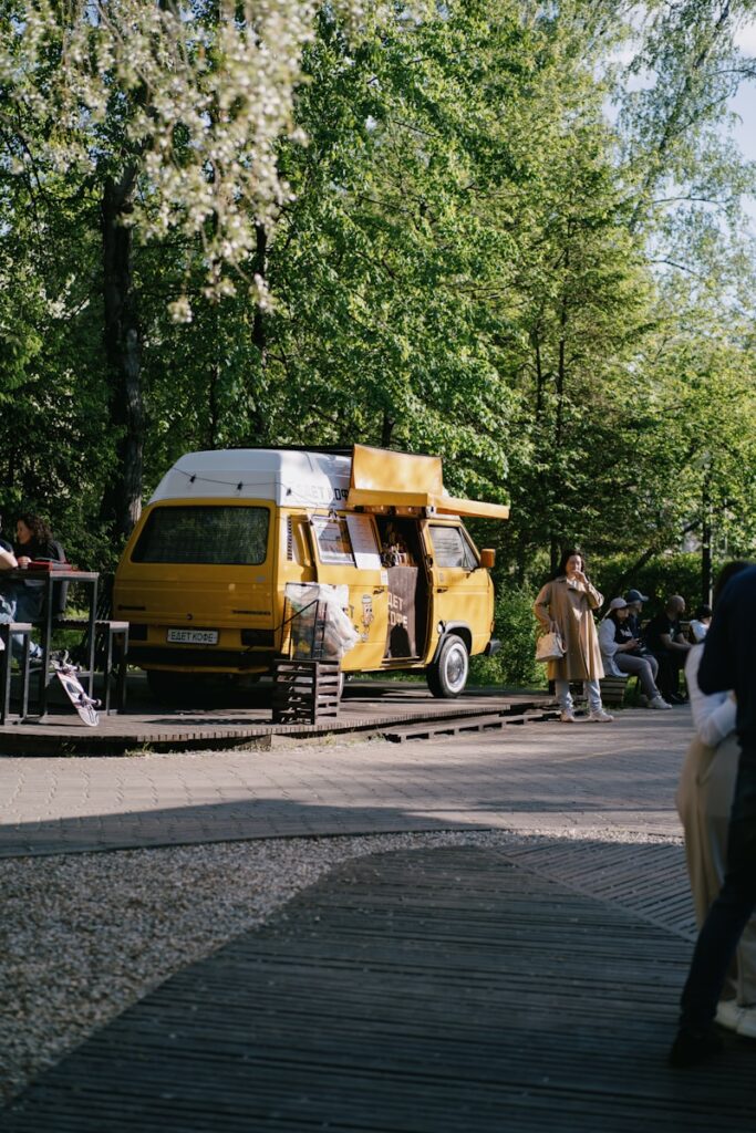a yellow van parked on the side of a train track