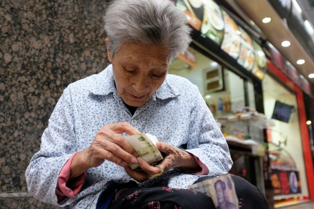A woman sitting on a bench looking at her cell phone