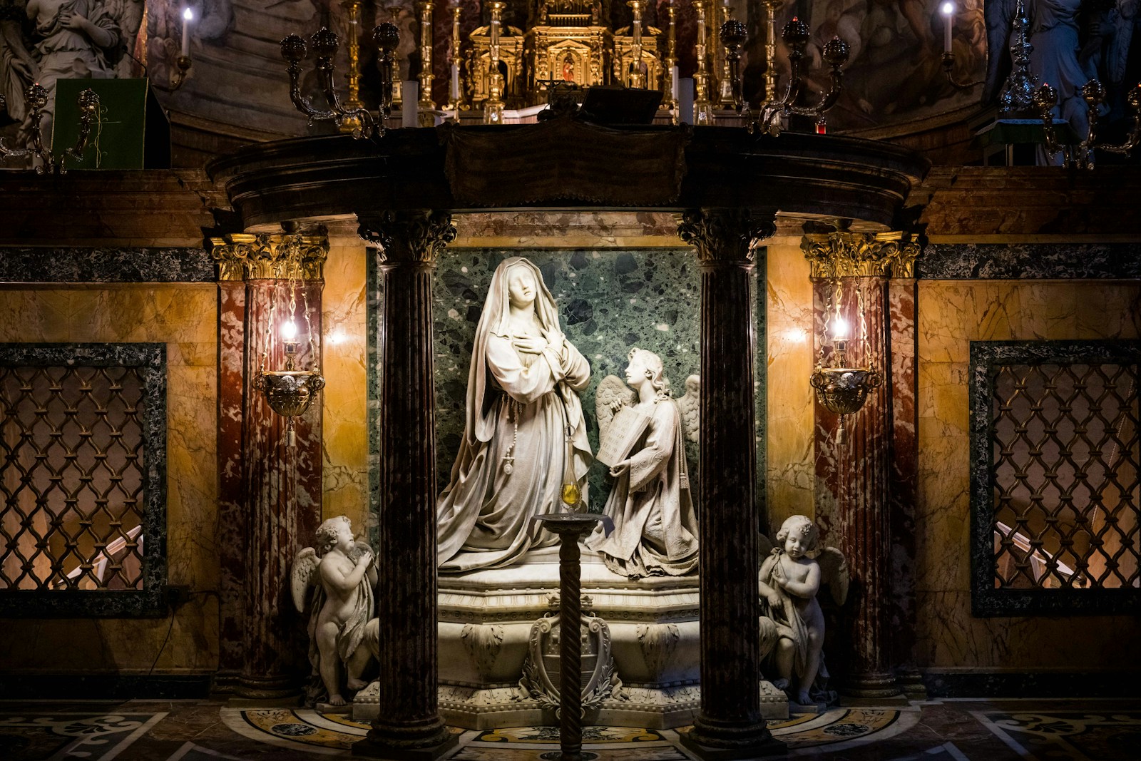 A marble sculpture is set inside a gilded shrine.