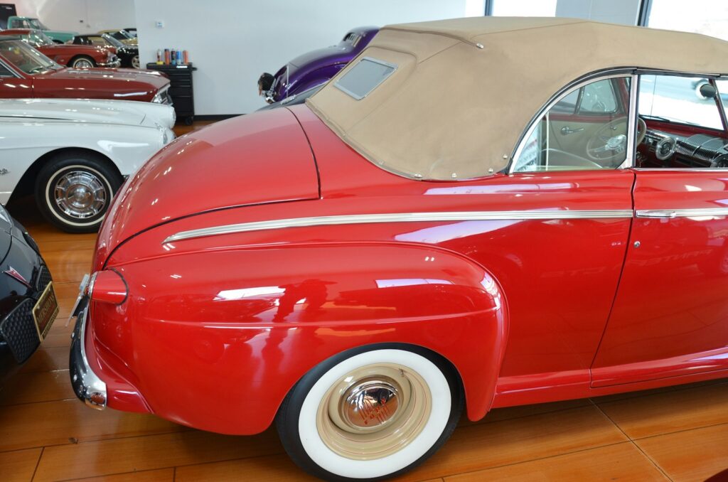 a red car parked in a garage next to other cars