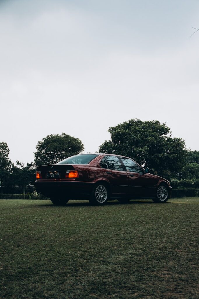 a car parked in a field with trees in the background