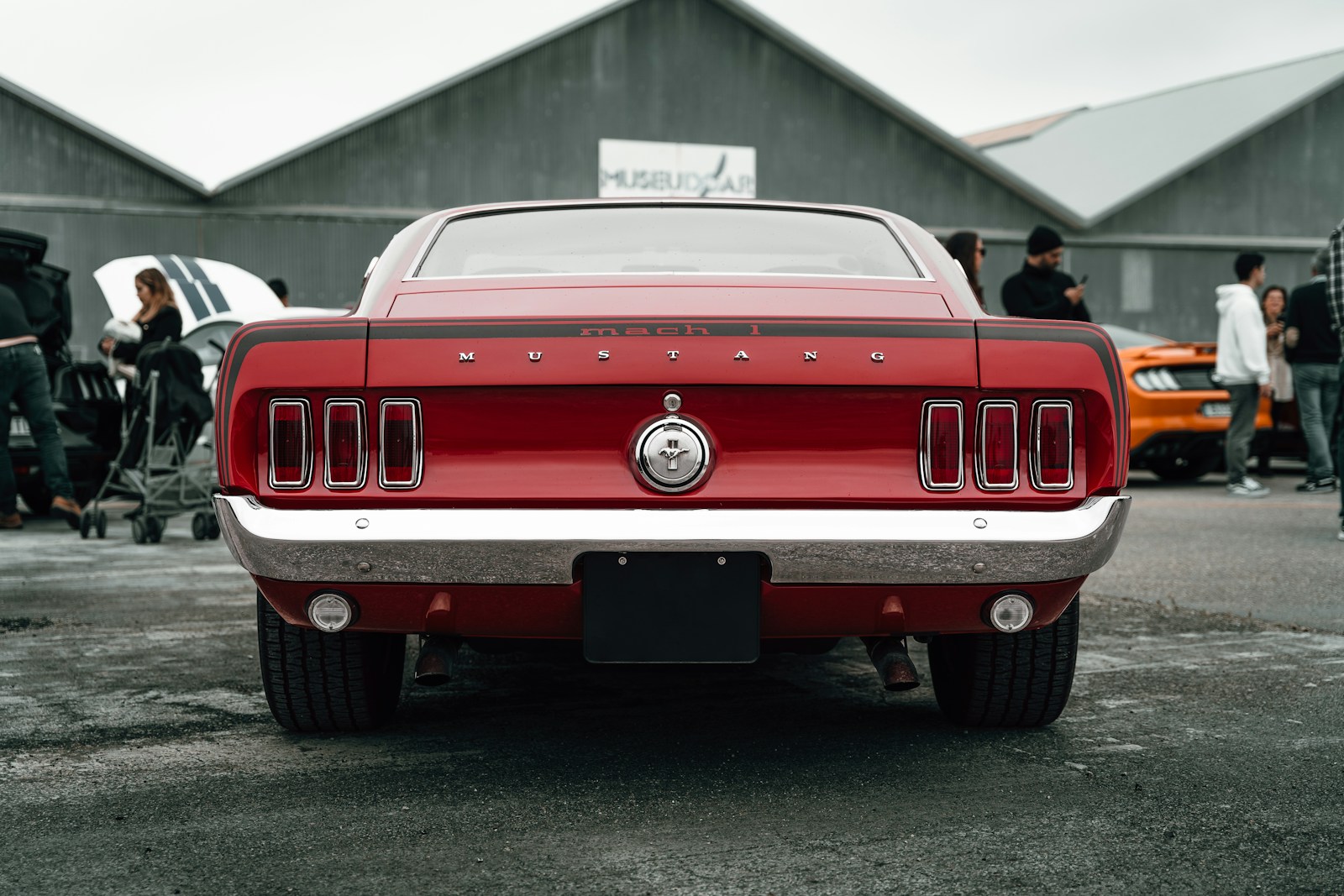 A red mustang parked in a parking lot