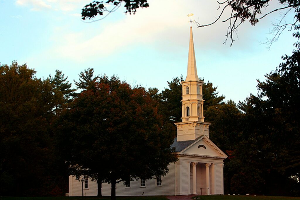 a church with a steeple surrounded by trees