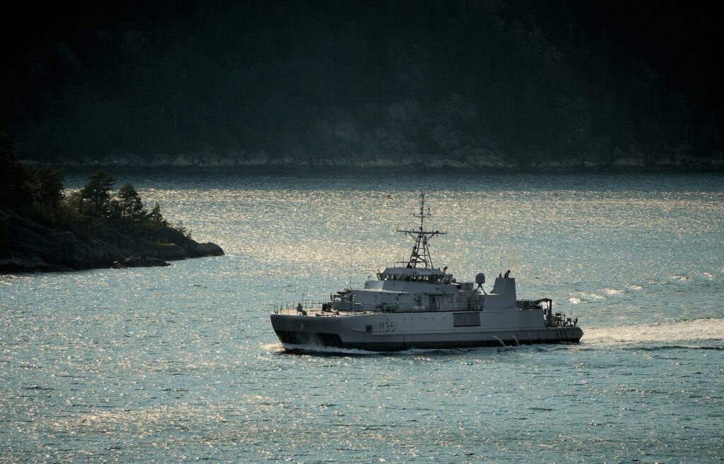 A ship sails across shimmering water.