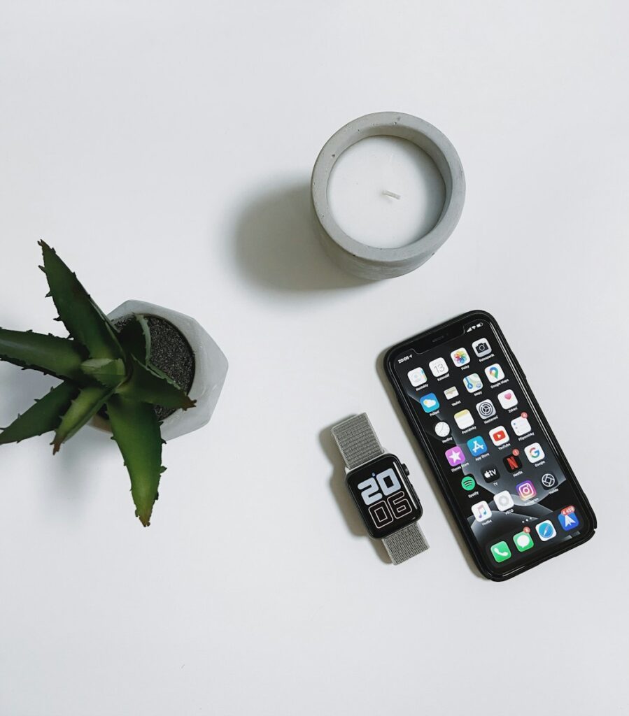 black iphone 4 beside white ceramic mug with saucer