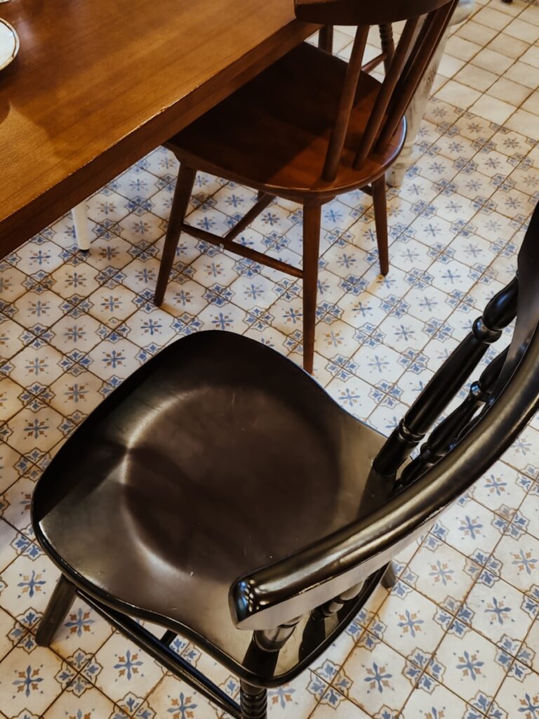 a black chair sitting in front of a wooden table