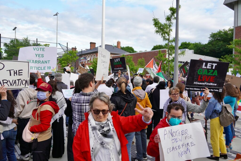 Protesters hold signs at a political rally.