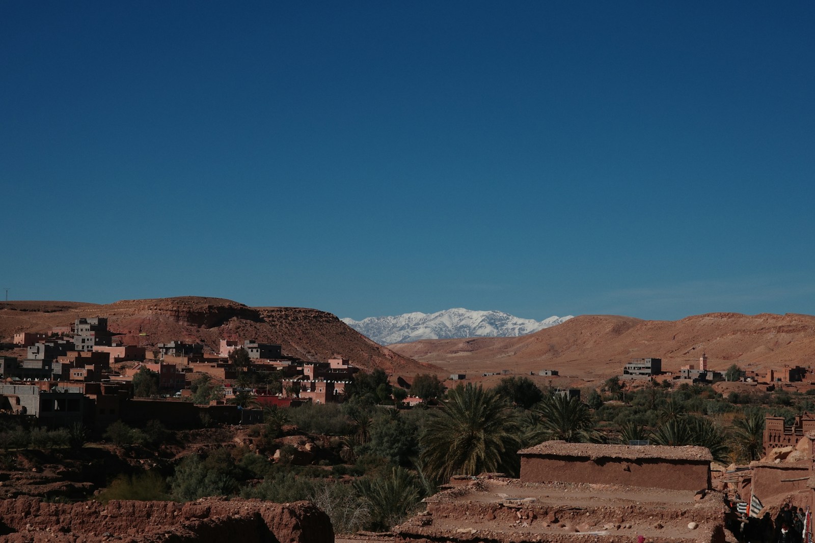 A small village in the desert with mountains in the background