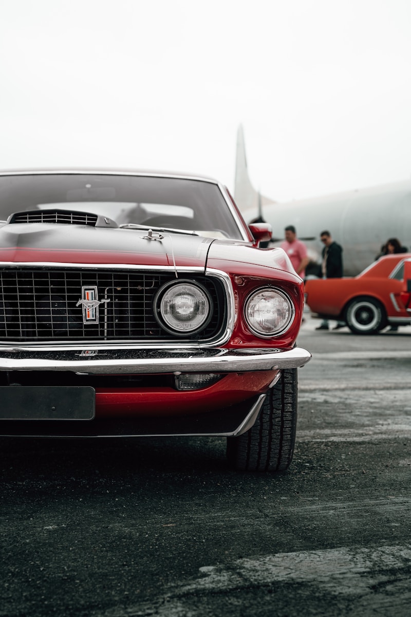 A red car parked in a parking lot next to other cars
