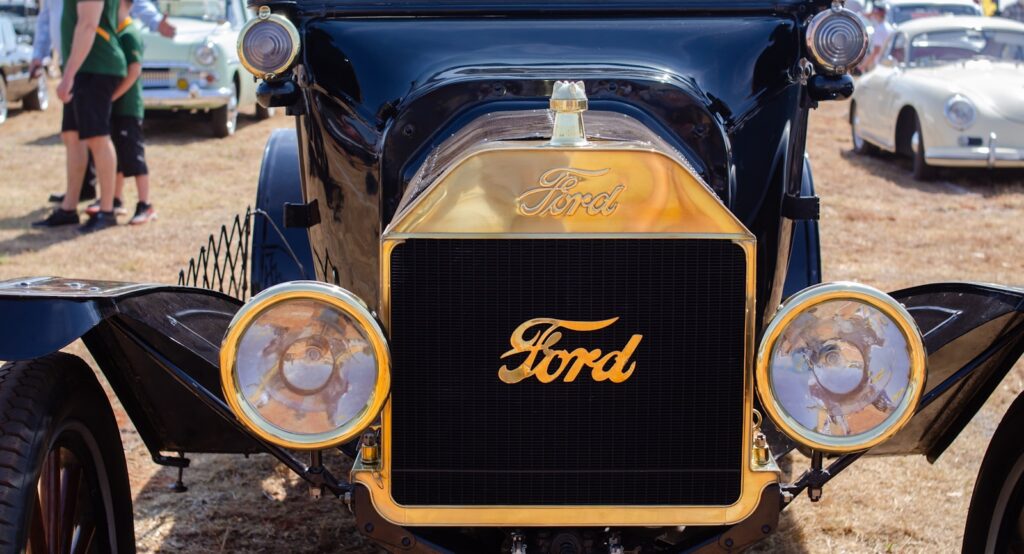 an antique ford car is parked in a field