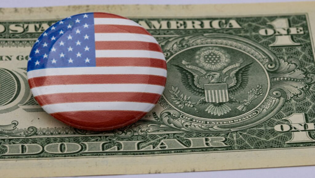 a button with the american flag on top of a one dollar bill