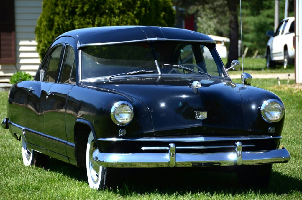 a black car parked on top of a lush green field