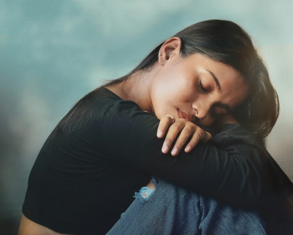 a woman sitting on a couch with her head on her hand