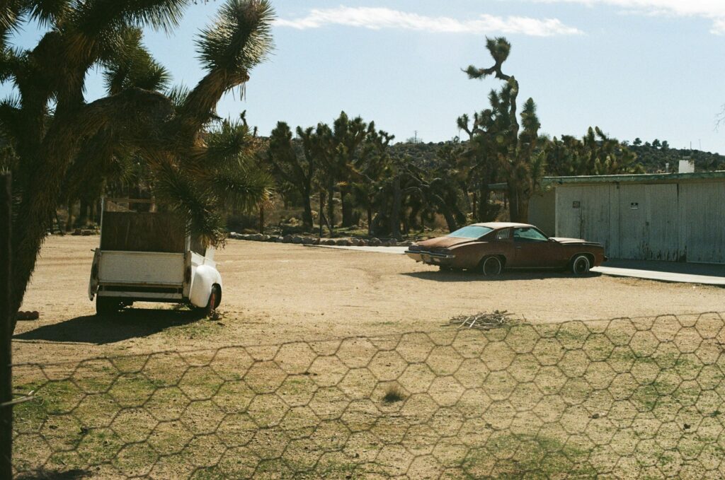 a car parked in a lot next to a fence
