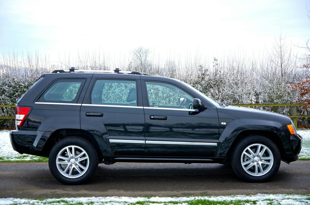 A black SUV parked outdoors on a snowy road surrounded by a winter landscape.