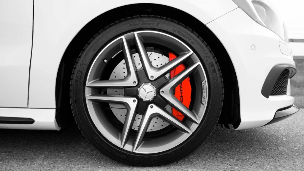 Detailed shot of a Mercedes-Benz wheel with a red brake caliper, emphasizing luxury and performance.