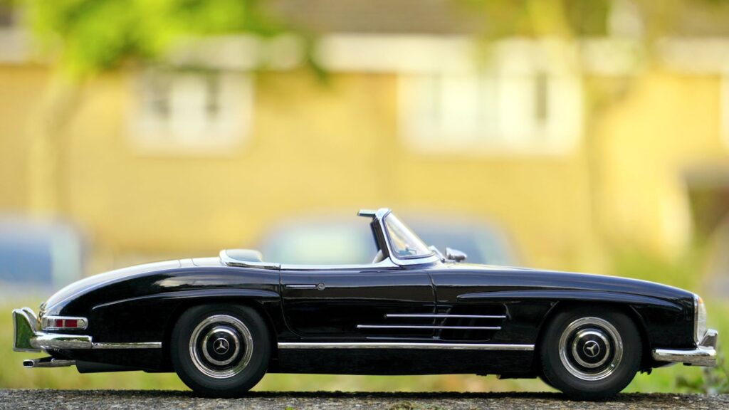 Close-up of a vintage Mercedes-Benz convertible toy car in an outdoor setting.