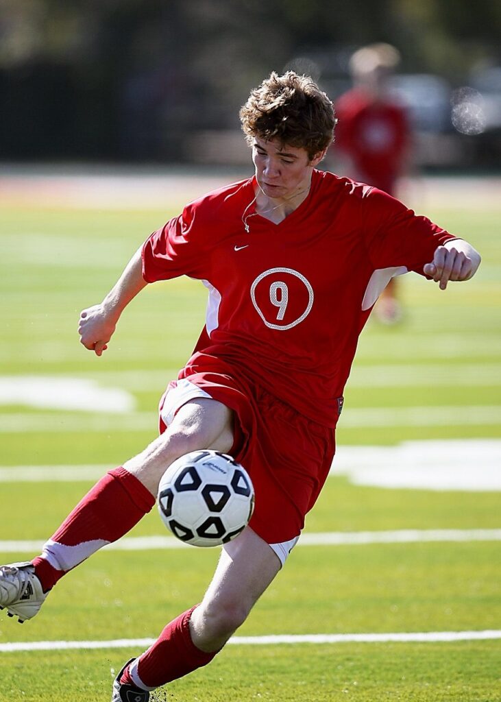 soccer, football, soccer player, sport, ball, game, player, field, grass, boy, action, soccer ball, sports balls, kicking, football player, nature, school, soccer team, athlete, high school, green, red, youth, action photo, kick