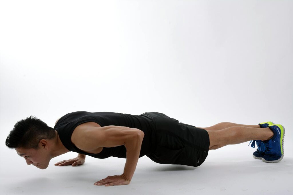 Young man in athletic wear doing push-ups, showcasing strength and fitness.