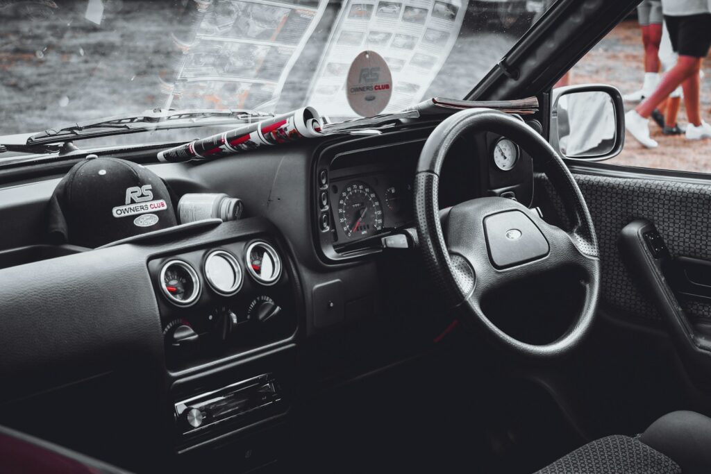 a car dashboard with a steering wheel and a dash board