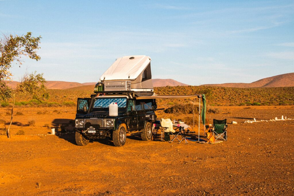 blue and white jeep wrangler on brown sand during daytime