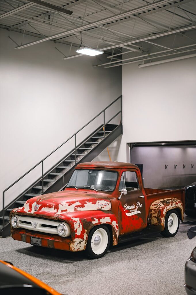 Classic red Ford F-Series pickup truck parked in an indoor garage setting.