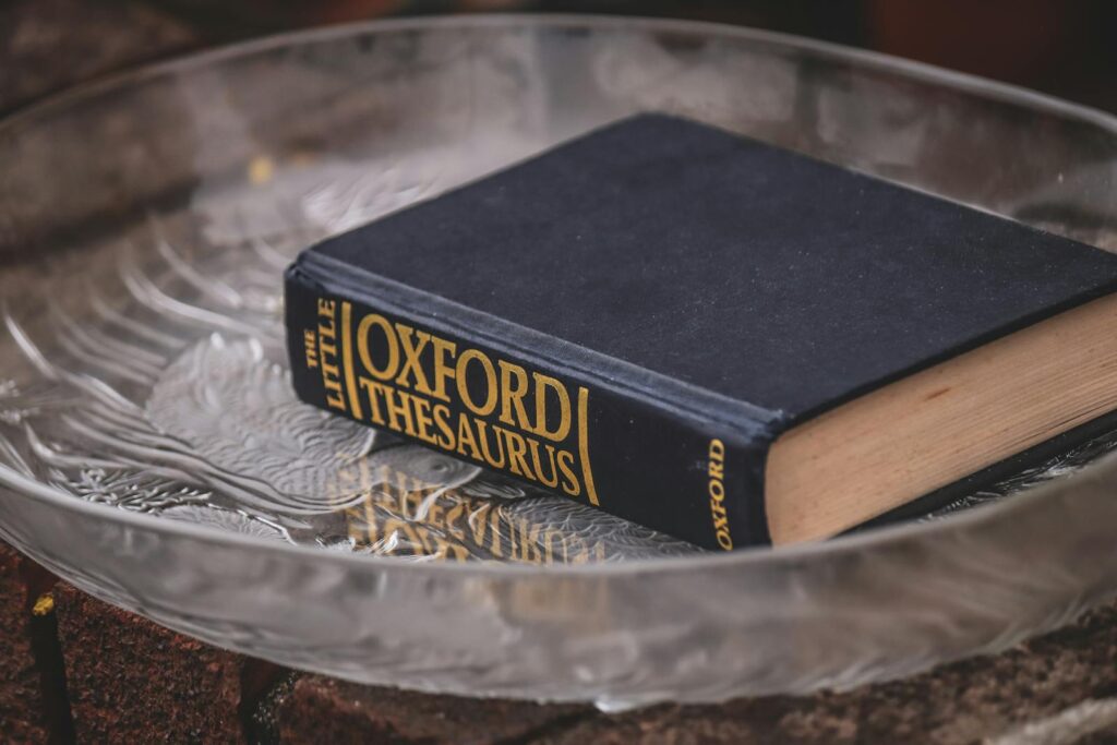 Elegant hardcover thesaurus with classic design on a textured glass plate.