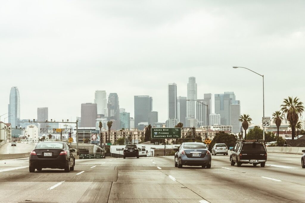 highway, cars, traffic, vehicles, towers, buildings, skyscrapers, los angeles, downtown, center, freeway, office center, city, nature, megalopolis, business centre, architecture, office, high-rise, multistory building, motion, road, asphalt, street, transport, sky, panorama