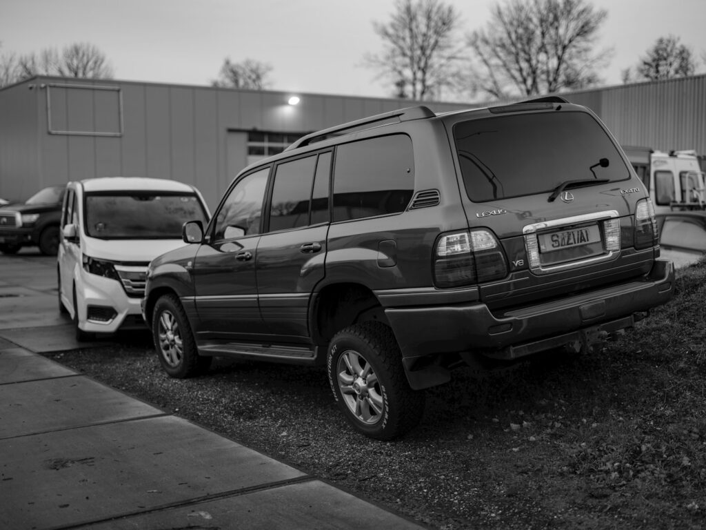 A black and white photo of cars parked in a parking lot