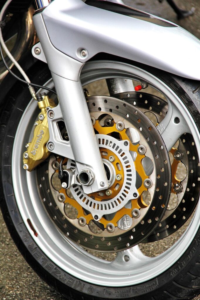 motorcycle, front wheel, bicycle, brake, disc brake, brake disc, tire, vehicle, wheel, motorsport, biker, caliper