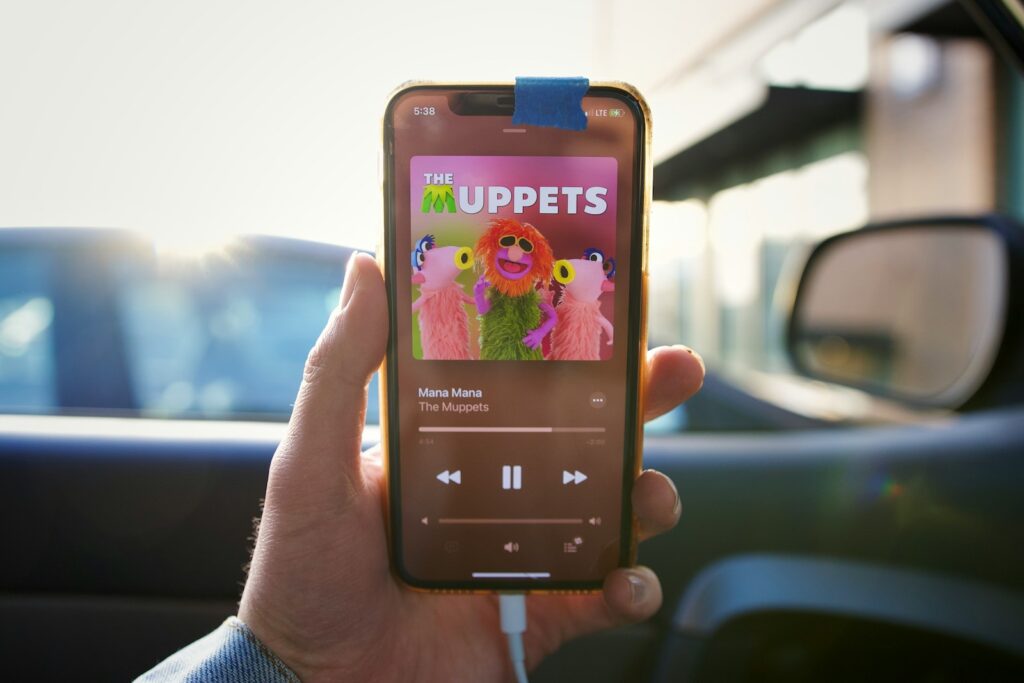 a person holding up a cell phone with the muppets on it