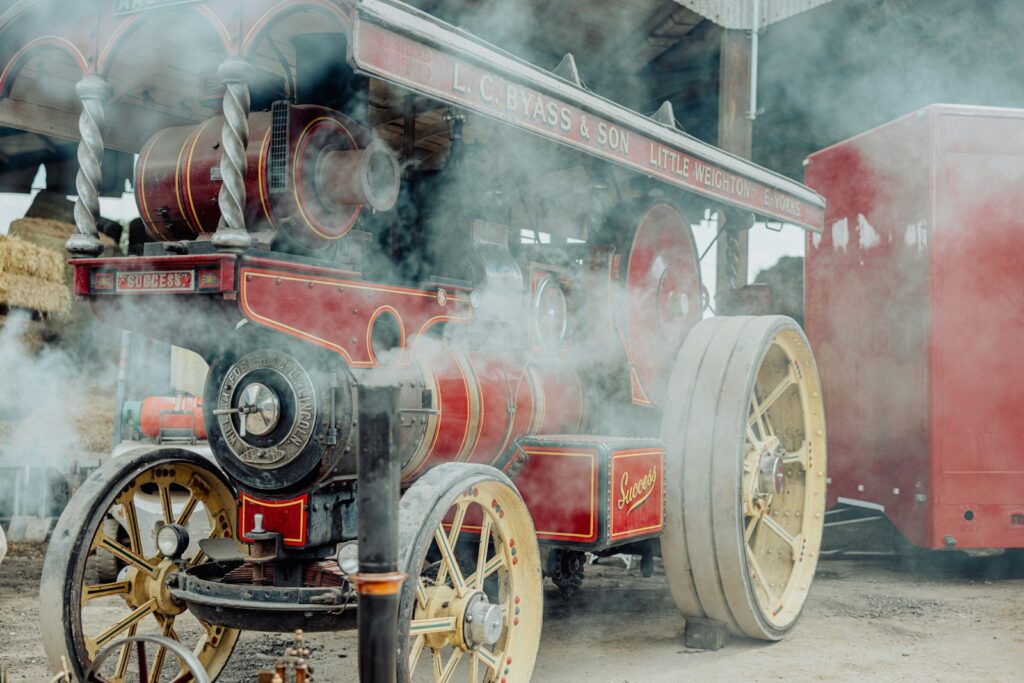 an old fashioned steam engine with steam coming out of it