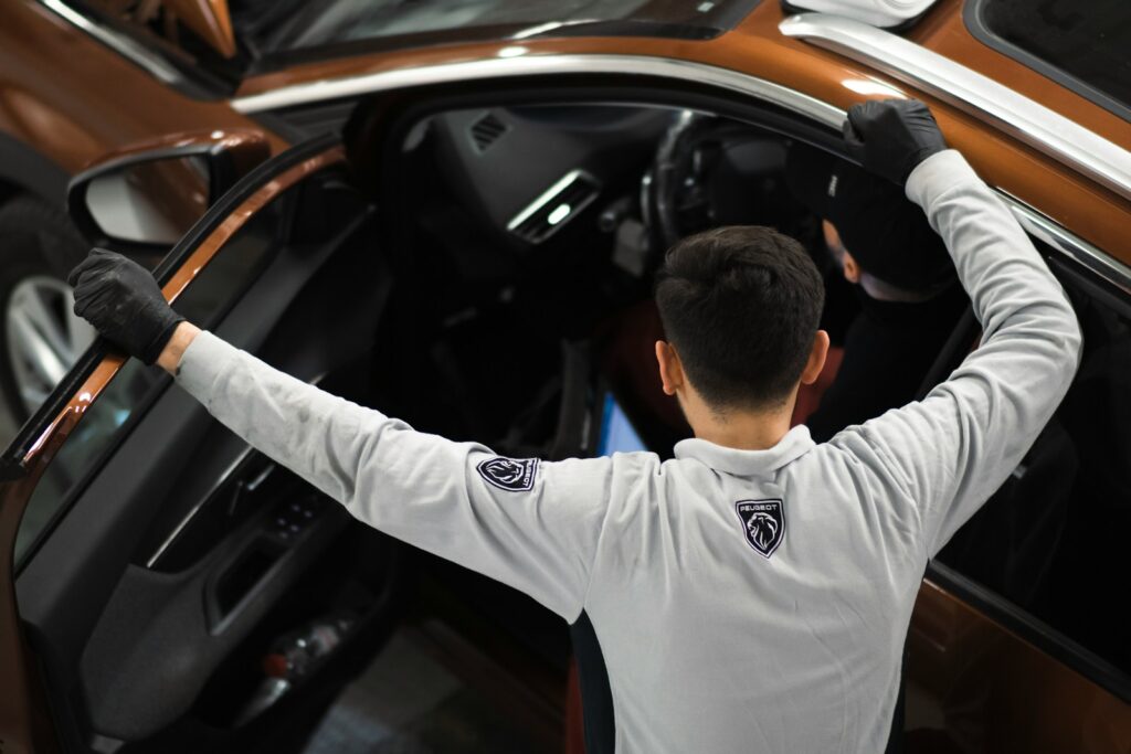 A man standing next to a brown car