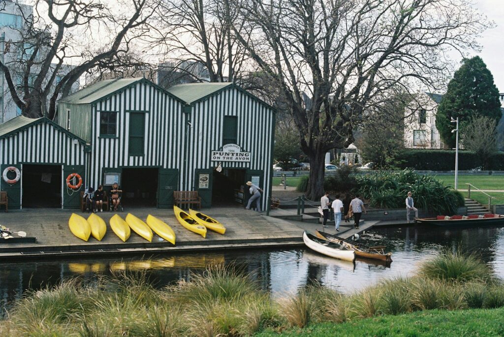 A group of people standing on a dock next to a body of water