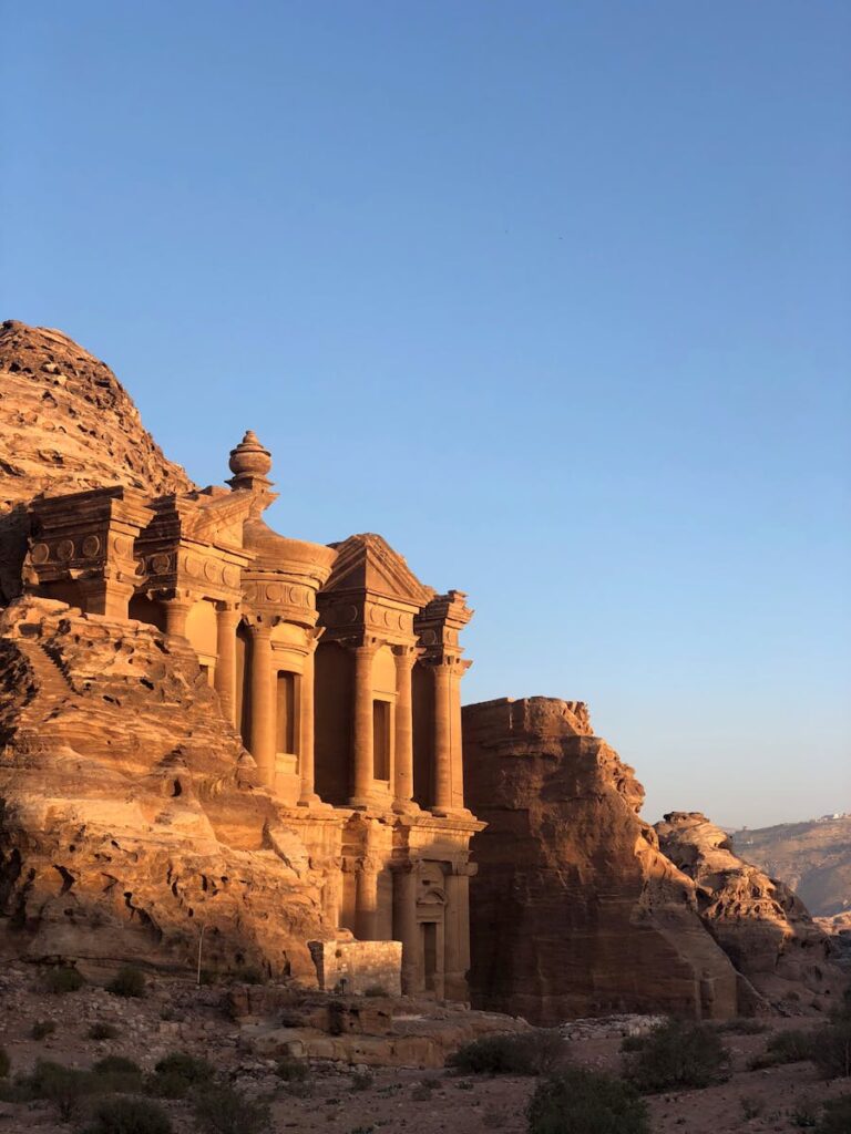Capture of the ancient Petra Monastery in Jordan illuminated by sunset, showcasing stunning sandstone architecture.