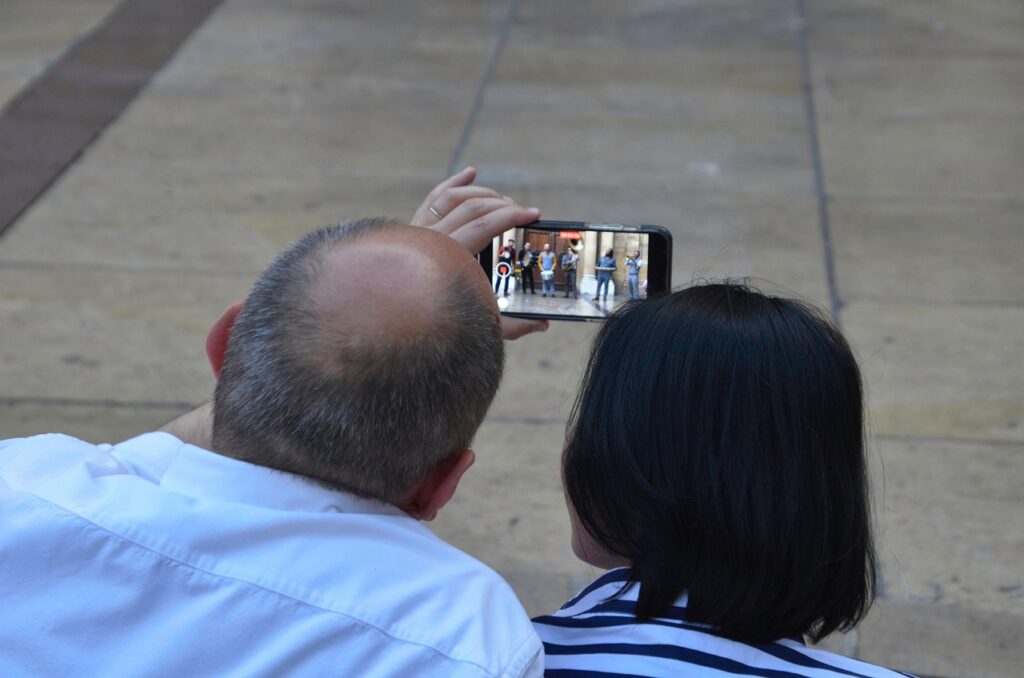 couple, watch, cellphone, together, entertainment, video, camera, outdoors, taking video, park, mobile phone