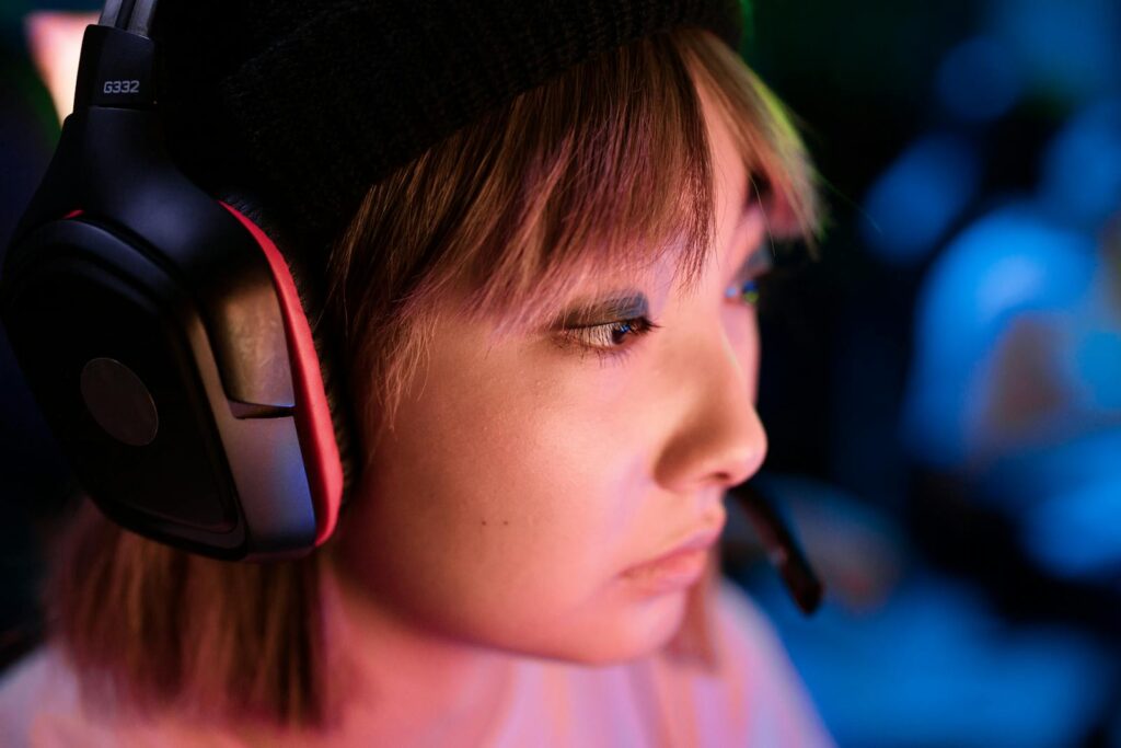 Profile view of a focused gamer wearing a headset intensely playing a game.