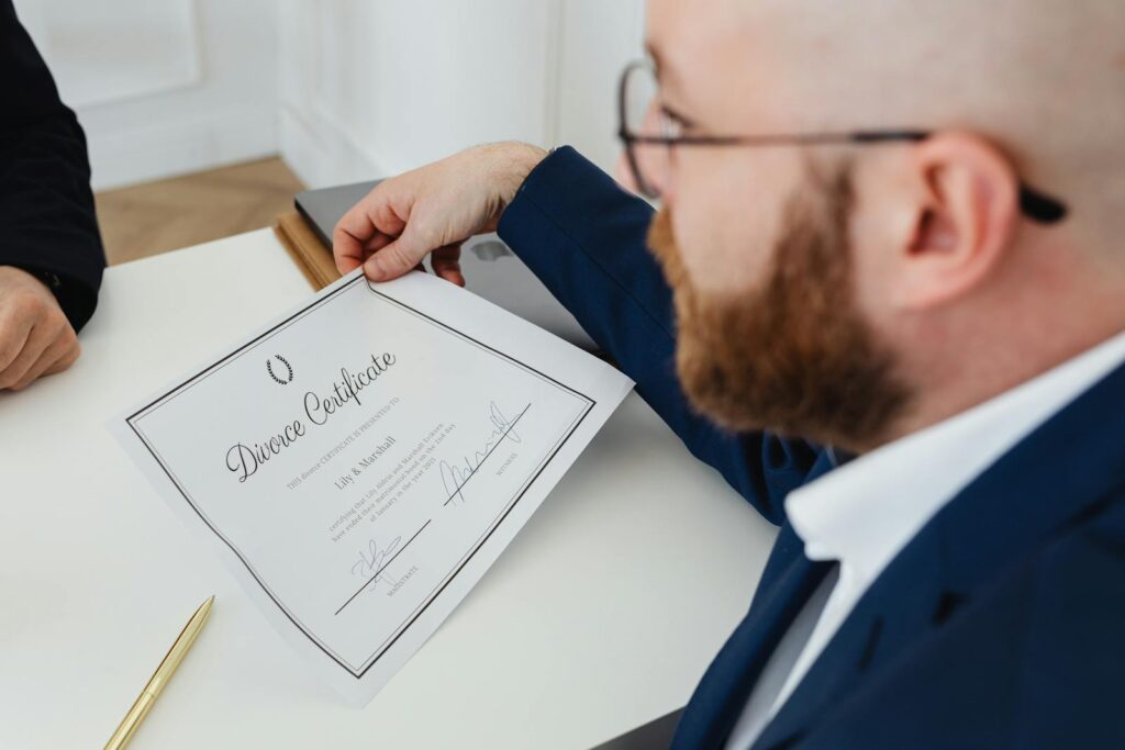 A man holding a divorce certificate in a formal office environment.