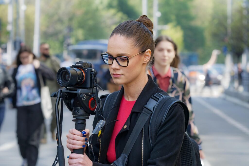 woman, filming, taking photos, eyeglasses, backpack, photographing, recording, digital camera, outdoors, street, urban