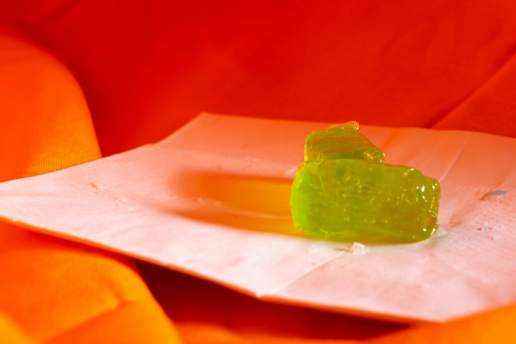 A piece of green gum sitting on top of a piece of white paper