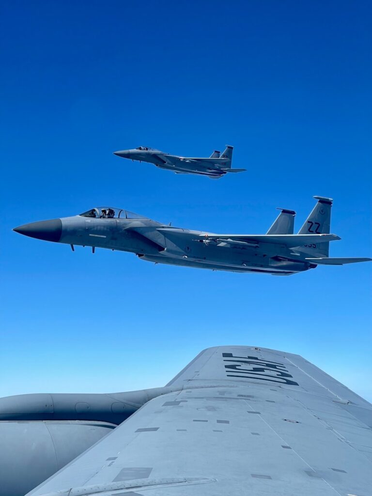 two fighter jets flying next to each other in the sky